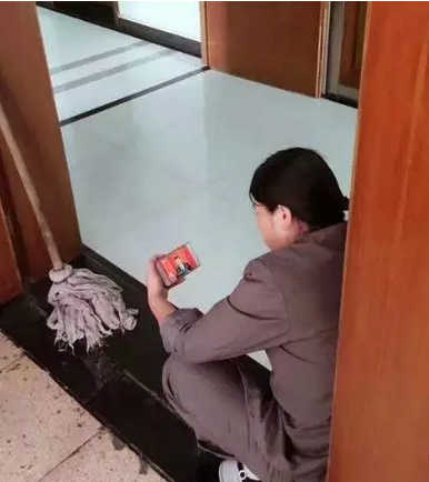 打扫卫生的阿姨在休息间隙看十九大直播